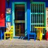 blue wooden door with red and blue wooden chairs
