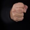 persons fist on black background