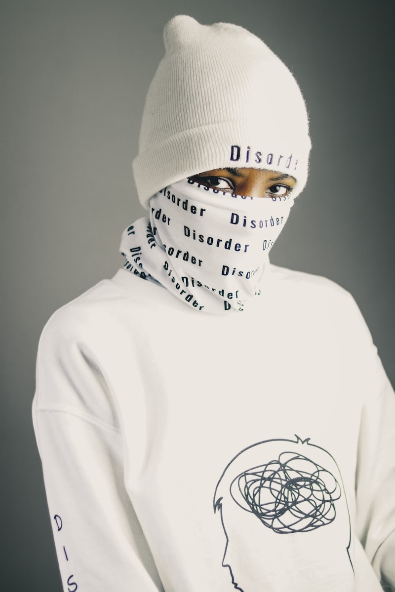 person in white and black crew neck shirt wearing white knit cap