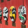 a row of masks on a red wall