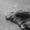 man in black jacket lying on ground