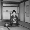 a woman sitting on a mat in a room