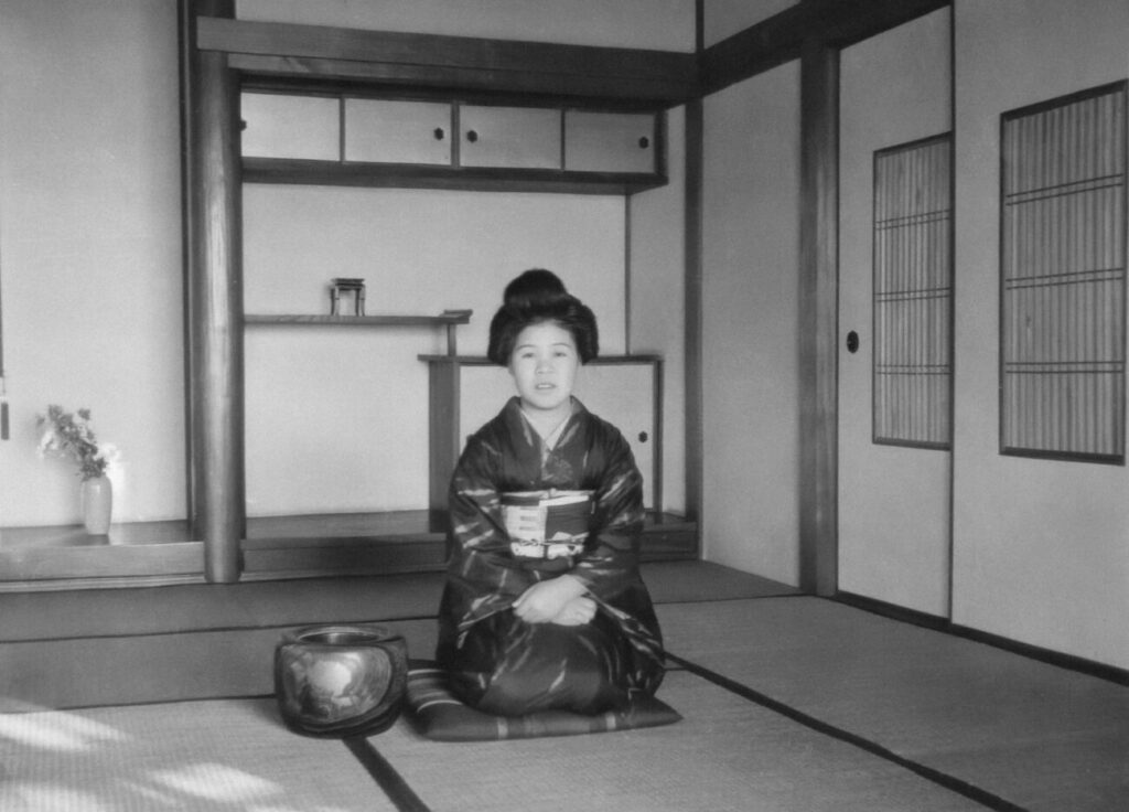 a woman sitting on a mat in a room