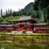 Japanese style temple near calm water behind mountain at daytime