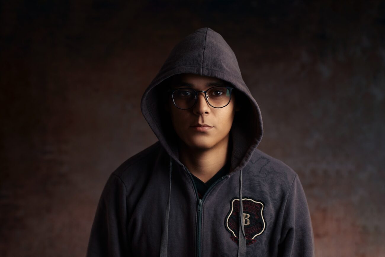 person wearing eyeglasses and gray zip-up hoodie