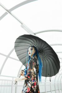 girl holding gray paper umbrella