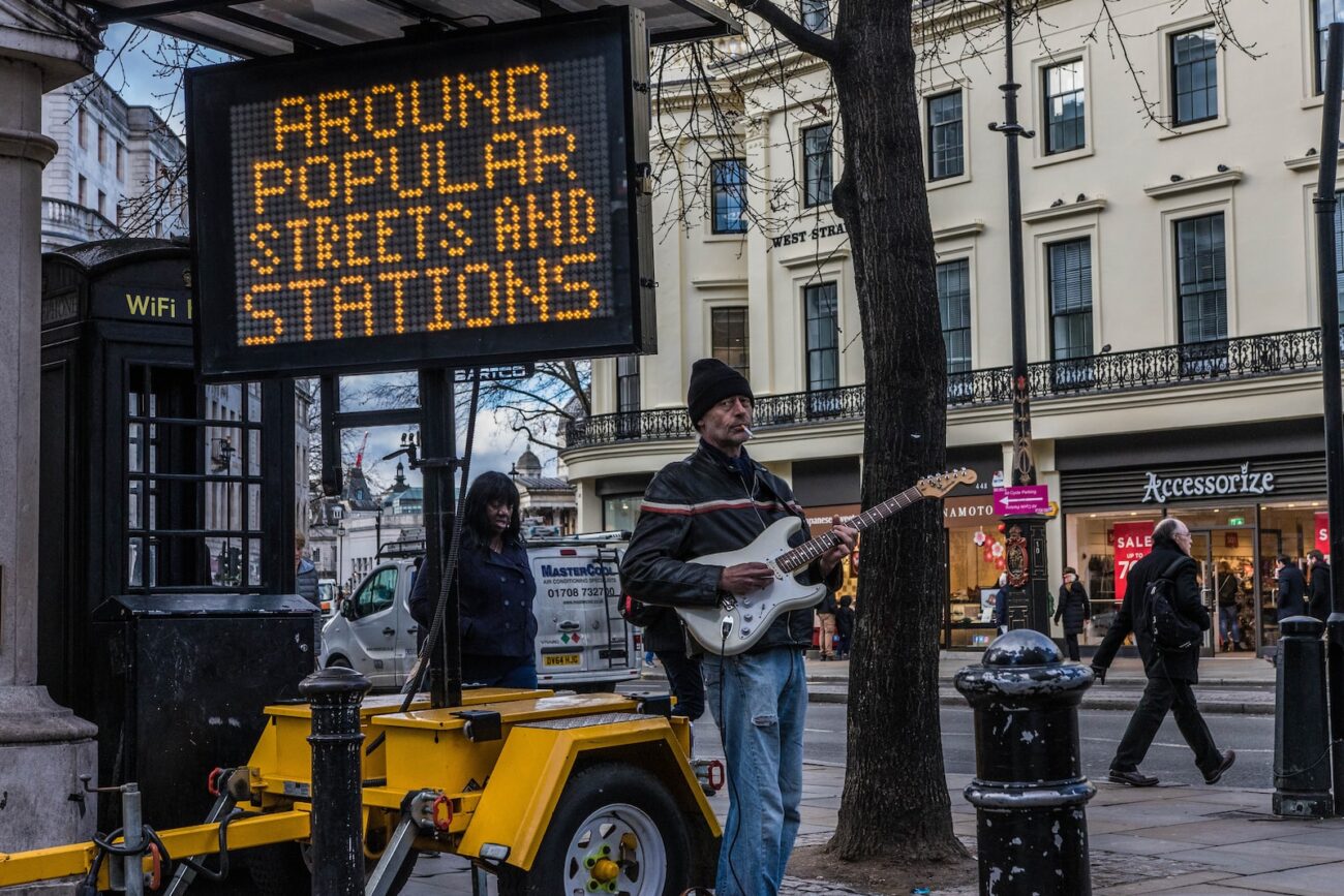 man playing guitar near LED signage