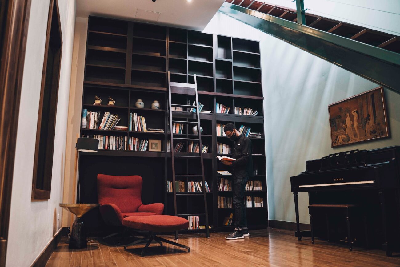 a red chair sitting in front of a book shelf filled with books