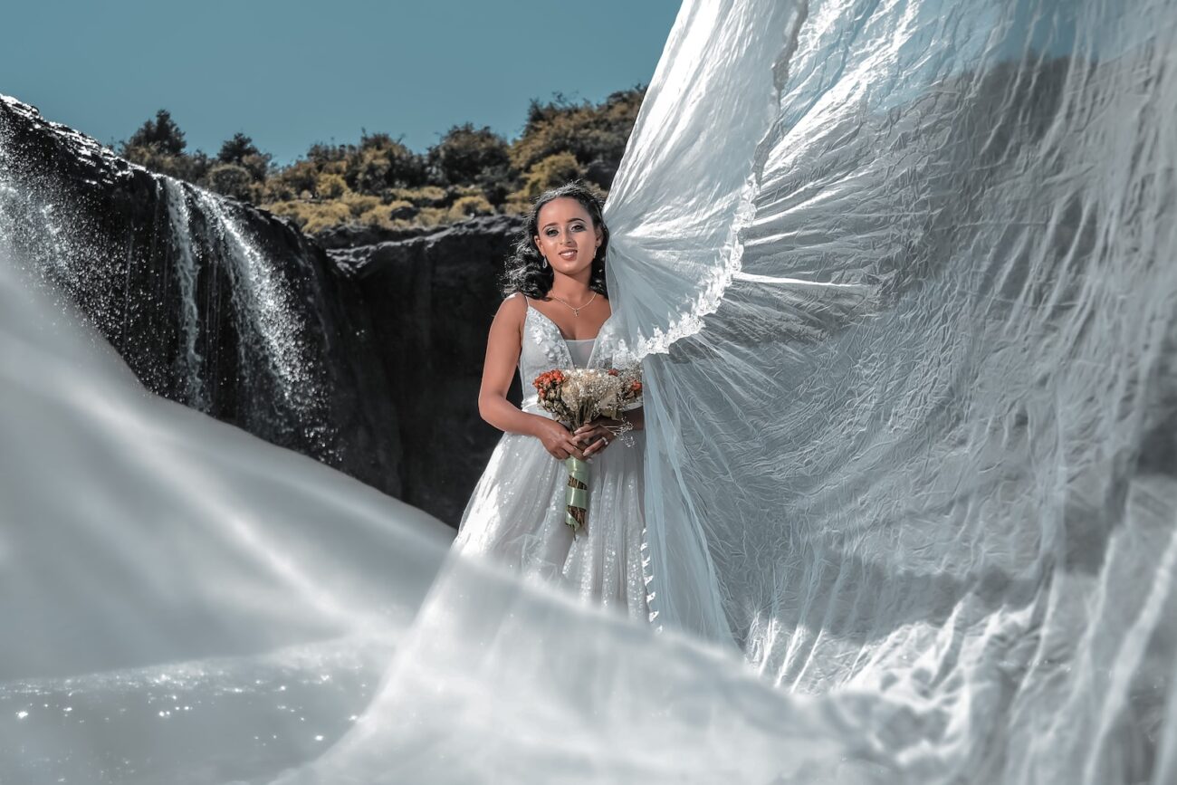 woman in white wedding gown standing on snow covered ground during daytime