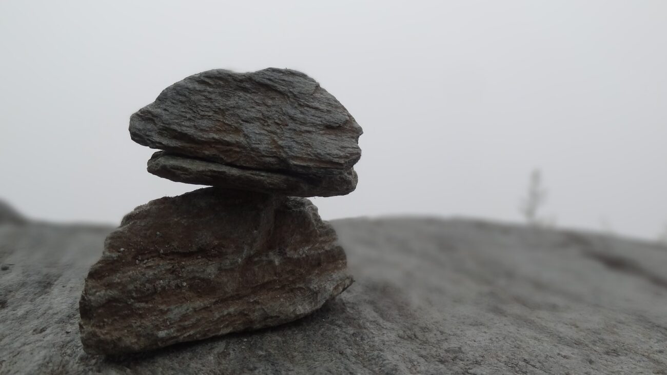 closeup photo of two gray stones on sand
