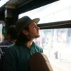 man staring outside of bus window