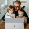 a man and two children looking at a laptop