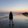 woman standing on seashore during blue hour