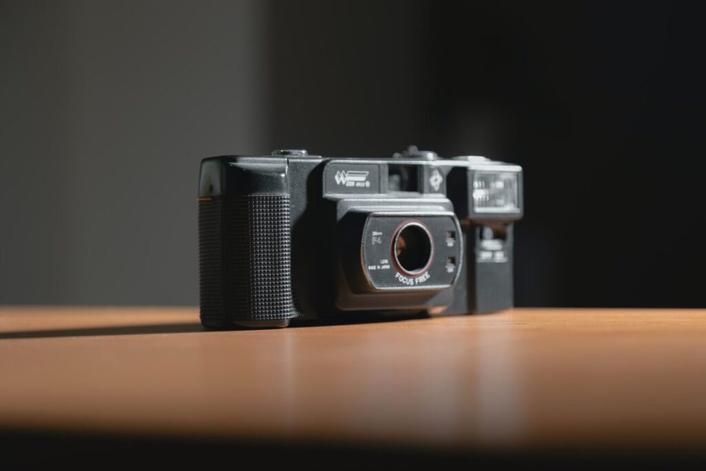 black and silver camera on brown wooden table