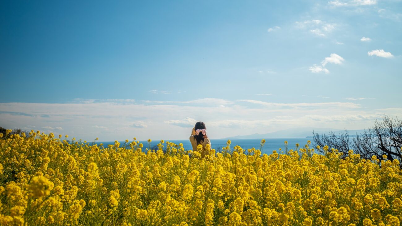 a woman standing in a field of yellow flowers