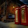 red telephone booth in front of brown brick building
