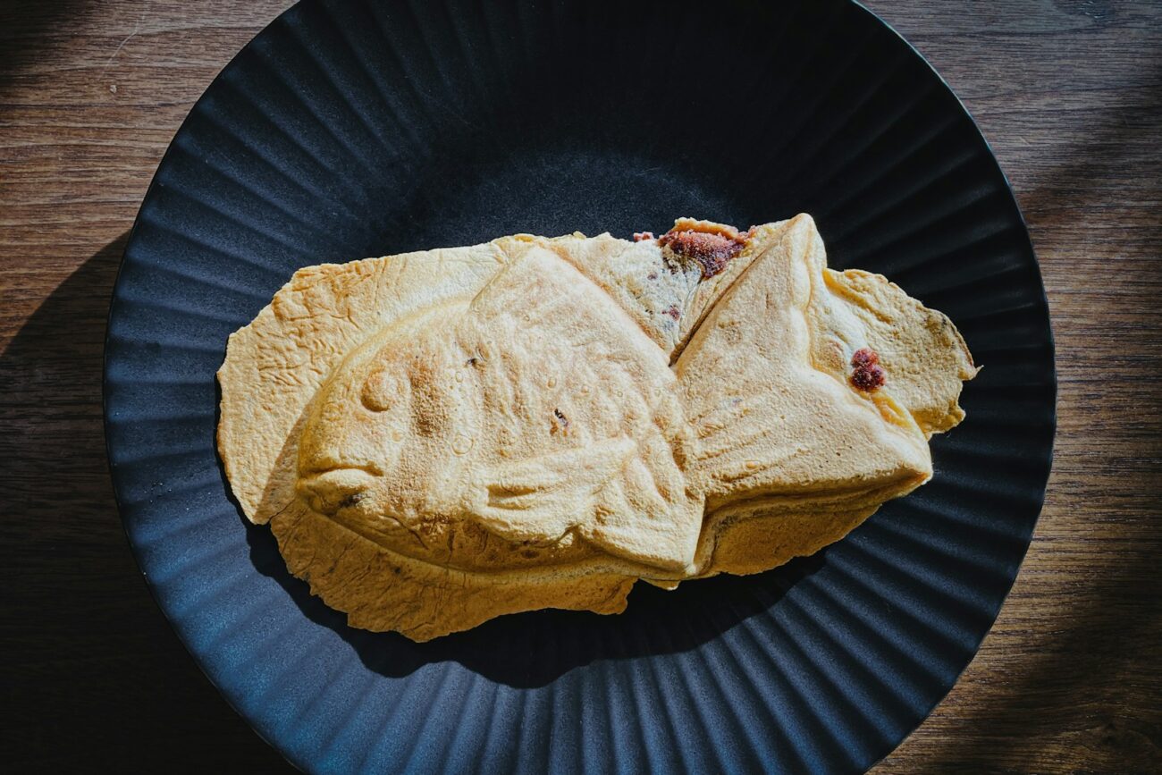 a black plate topped with a cut in half sandwich