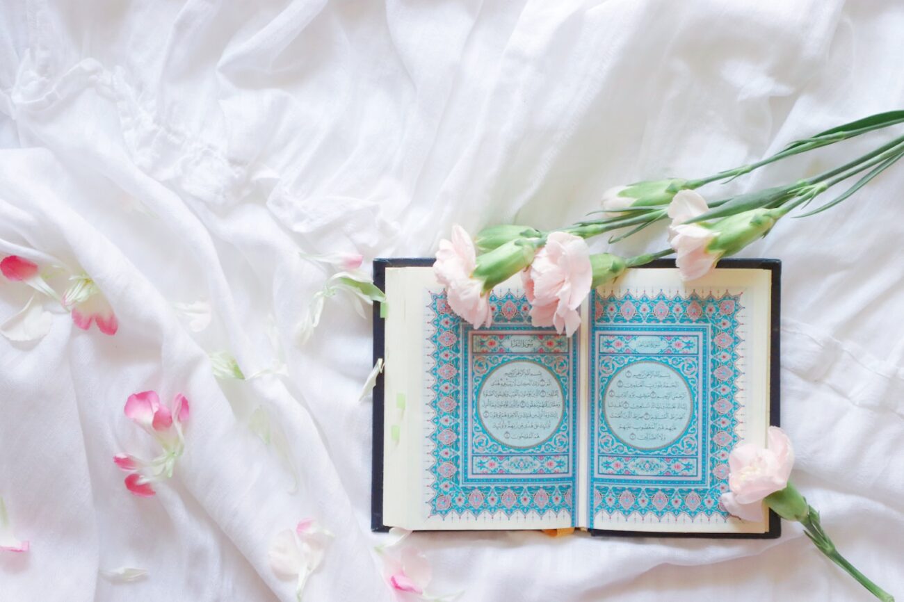 blue and white book on white and pink floral textile