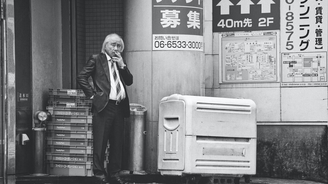 grayscale photo of man smoking cigarette