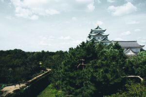 white and black temple surrounded by green trees under white clouds during daytime
